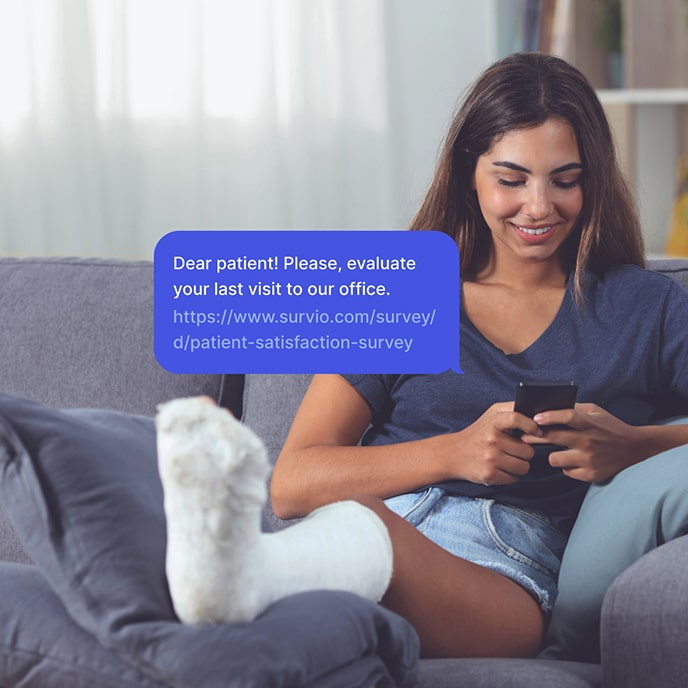 A girl with her leg in a cast fills out a patient's form on her mobile phone.