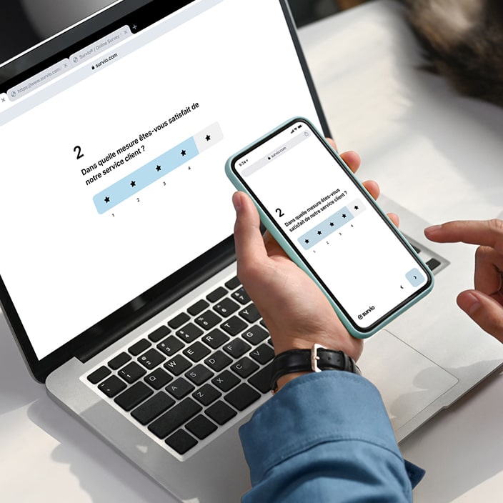 Une question d'évaluation par étoiles affichée sur un ordinateur portable et un téléphone mobile pour démontrer la conception réactive de la plateforme Survio sur plusieurs appareils